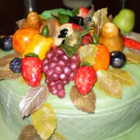 Nature's Bounty Fruits and vegetables modelled from marzipan and complement with fondant leaves adorn this fruitcake covered with green fondant icing.