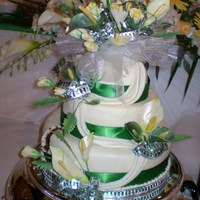 Calla Lillies And Roses Burst Calla lilles and roses done in the bridal theme colours of cream, pale yellow and green. Covered in cream fondant with drapes and green...