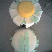 Daisy Cake Red velvet cake w/ cream cheese filling. Fondant icing on the cake, the leaves and daisy petals. Large sugar cookie for the yellow portion...