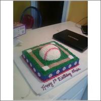 Baseball square cake with 1/2 ball pan baseball on top. little painted fondant baseballs on side, graham cracker crumb field