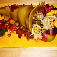 Cornucopia Carrot cake covered in fondant. Rice crispy bases for apple, corn, and gourd. Chocolate melts in homemade molds for acorns and walnuts....