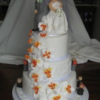 Wedding Cake round wedding cake with sugarpaste bride and groom models and orchids made from artista soft. The little models around the cake tell a...