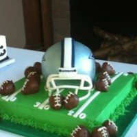 Dallas Cowboys Helmet 12" square cake as football field. Helmet is two 6" rounds and half the ball pan and was then sculpted. Face mask is gum paste...