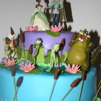 Princess And The Frog fondant with store bought figures . the pussy willows are made with spaghetti uncooked and the water is colored piping gel