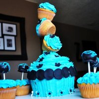 Topsy Turvy Cupcake! Giant cupcake made with wilton cupcake pan decorated with regular cupcakes. American Buttercream Icing with fondant and gumpaste accents.