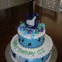 Electric Guiter Cake Two tier banana cake iced in buttercream. Molded chocolate electric guitar anf music notes.