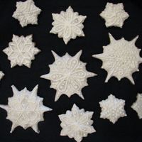 Snowflakes Gingerbread with Royal icing, sprinkled with crushed Wilton cake sparkles, then lines piped with royal icing over top.