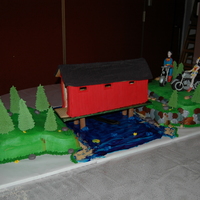 3D Wedding Cake Bride wanted a covered bridge made out of ginger bread with cakes on each side carved into landscaping along with rocks, water, cat tails,...
