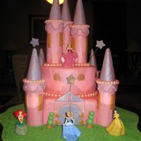 Disney Princesses Castle Cake Two tier chocolate cake covered with foundant. Towers are made by ice-cream cones covered in foundant.
