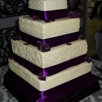 Purple Wedding! Traditional white-on-white wedding cake, WASC with vanilla buttercream! Piping in buttercream, roses and leaves made from modeling...