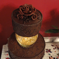 Michelle's 40Th Birthday Chocolate cake with dark chocolate buttercream. Topped with my first attempts at modeling chocolate roses. Glass dome separator had battery...