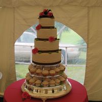 Wedding Cake Over Cupcakes Four tiered, buttercream iced cake sitting over two tiers of cupcakes