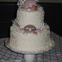 Sea Shell Cake Buttercream iced cake decorated with piped white chocolate coral and molded chocolate shells, brushed with assorted luster dusts