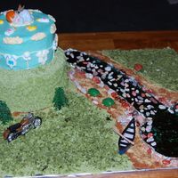 Nature Lovers Baby Shower Cake two tier chocolate cake with raspberry filling. The stream/lake are made out of hard candy, the grass is coconut, the rocks are chocolate...
