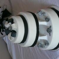 Black & White Bow Chocolate, vanilla & orange sponges. Iced in fondant & gumpaste with petal paste roses.