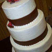 Megan's Chocolate And Crimson 10, 8, 6 white cake with BC icing. Chocolate fondant ribbon, and fondant roses. First 3 tiered cake... your thoughts or suggestions welcome...