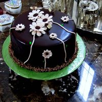 121625851258727.jpg This is a Chocolate Cake with Chocolate Ganache, I made the flowers out of gumpaste.