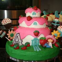 Strawberry Shortcake Vanilla cake with covered in buttercream with choc ganache filling. Pink on house is MMF and molded chocolate accents. Strawberry Shortcake...