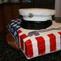 Military Cap On Flag Chocolate cake with chocolate fudge icing. Covered in MMF. Stripes are hand painted on. Used rice crispy treats to form the top of the hat...