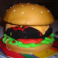 Burger french vanilla bun covered in MMF; chocolate patty covered in chocolate frosting and oreo crumbs; MMF lettuce, tomato, and cheese; frosting...