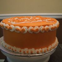 Orange A dummy cake with orange and white buttercream decorations.