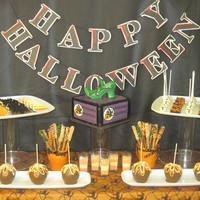 Halloween Dessert Buffet Table Clockwise from top left: vanilla and chocolate cookies in pumpkins, candy corn and bat shapes; chocolate shoe box cake with swiss meringue...