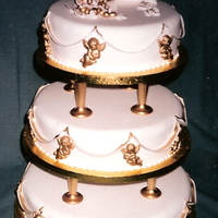Golden Cherub & Cornucopia Wedding Cake Three tier all fruit cake covered in fondant icing, with golden cherubs & a cornucopia of golden grapes & vine leaves.