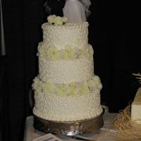 White Traditional With Carnations Of course, we had to have a traditional cake to display. Simple, white on white butter creme with white carnations. It is topped with a...