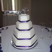 Hexagon Wedding Cake My first attempt at covering hexagon cake in fondant. Added purple ribbon around the bottom with rhinestone hearts.
