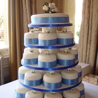 50 Mini Cakes - 5 Tiers Tall! 10" round fruit cake with 40 round 4" wedding cake..... a small bouquet of roses on the top tier and a single rose on each of the...
