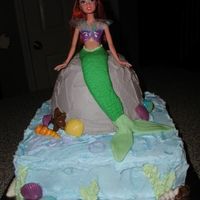 Ariel Birthday Cake An actual Ariel doll is sitting in a bowl cake. The doll was longer, so her feet are also going into the 10" square cake. The cake is...