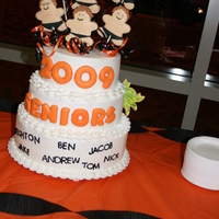 Swim Team Tiered vanilla cake with buttercream icing topped with boy shaped sugar cookies decorated with royal icing.