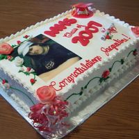 Graduation banana and chocolate cake decorated with non-dairy whipped frosting, fondant roses and rice paper picture