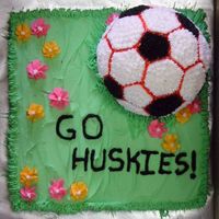 Go Huskies Golden butter cake with soccerball with team colors (black and red) on a "grassy" field with flowers - of course it's a girl...