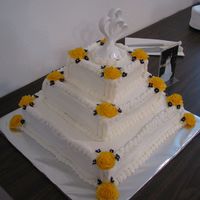 Yellow Rose Cake 3 tier wedding cake. Butter cream frosting. Buttercream yellow roses. Silk accent blue flowers.