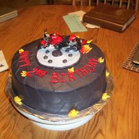 Motorcycle/wheel Bday Cake 10" round iced in blk and marked like a tire. Added the mtrcycle on the top and filled in with the fire.