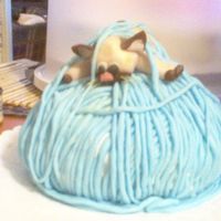 Kitty And Yarn This is a cake that I did for my Aunt. She loves siamese cats. I did this for her birthday with a ball cake pan. I cut some off the bottom...