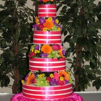 4 Tier Ribbon Cake 16 inch orange cake, 12 inch white cake, 9 inch strawberry cake, 6 inch white cake. Each covered in buttercream icing, with 3 bands of...