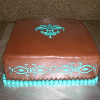 Fleur De Lis Chocolate Fondant with turquoise royal icing stenciled on cake. Cake was triple chocolate with caramel filling.