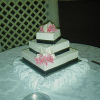 Quilted Wedding Cake French Vanilla with custard filling, buttercream icing, black satin ribbon border, dragees in the crosshatches of the quilting. Silk...
