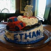 Ethan's 3Rd Bday Cake two tiers with a carved road, covered in buttercream, road is black sprinkles, car is actually a car shaped cupcake covered in buttercream...
