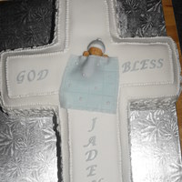 Jaden's Baptism Vanilla Cake carved and filled with vanilla buttercream. Covered in fondant, gumpaste baby and blanket. Royal icing beading and cornelli...