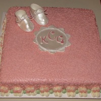 Baby Booties Fondant/Gumpaste baby booties that are sprayed with pearl luster dust. The border is baby booties made from buttercream. The green dots are...