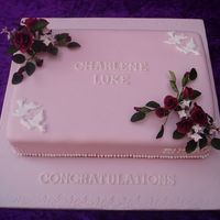 Engagement Cake With Roses And Doves Engagement cake with handmade sugar sprays of red roses and runout doves on the corners.