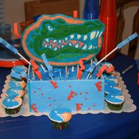 Gator Cake buttercream cake with fondant panels. Gator head is made out of chocolate. Football helmet cupcakes