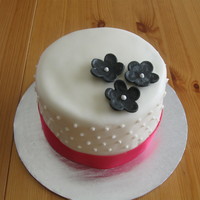 Small Fondant Wedding Cake With Fondant Flowers 6 inch round covered with fondant and bordered with hot pink satin ribbon. To go with cupcakes.