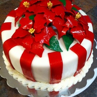 Poinsettia Cake Cake covered in fodant. Flowers and leaves are gumpaste.