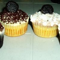 Black & White Cupcakes In detail: (from left to right) Chocolate cupcake with vanilla frosting, vanilla cupcake with vanilla frosting, both are topped with...