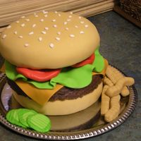 Cheeseburger Cake The buns are made of white cake with buttercream icing covered in fondant. The hamburger is made out of rice crispy treats covered in...