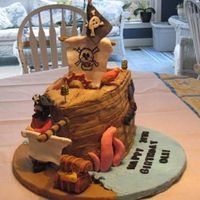 Pirate Ship I made this for my husband's birthday. It had a pirate, parrot, kracken, treaure chest, cannons and edible fondant sails.